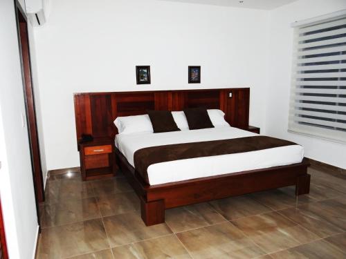 a bedroom with a large bed with a wooden headboard at La Bocana de Quiximies Hotel in Cojimíes