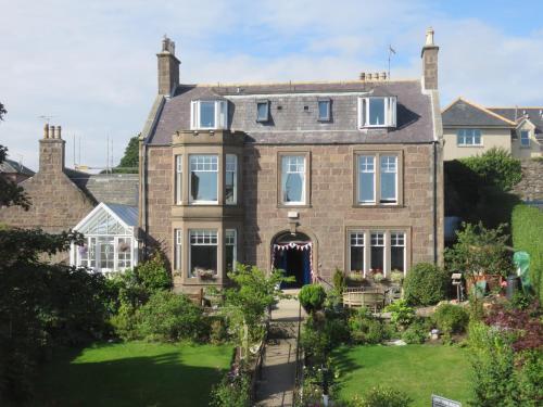 a large brick house with a garden in front of it at Arduthie House in Stonehaven