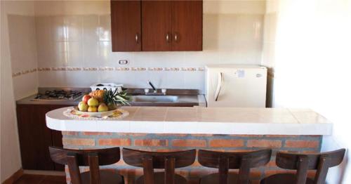a kitchen with a counter with chairs and a sink and a refrigerator at Hacienda Sanmiguel de la Prada in Los Santos