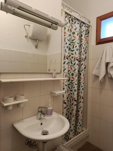 a bathroom with a sink and a shower curtain at La Villetta in Vittorito