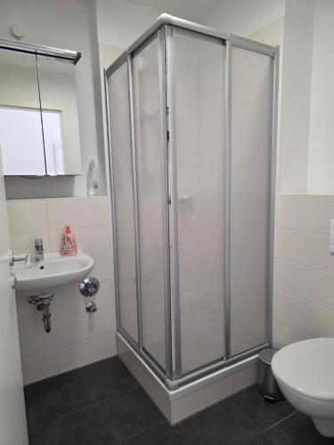 a bathroom with a shower and a toilet and a sink at Hotelappartements BR in Fürth