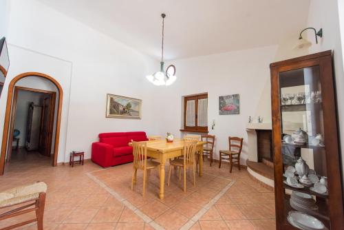 een woonkamer met een tafel en een rode bank bij Villa Letizia in Scorrano