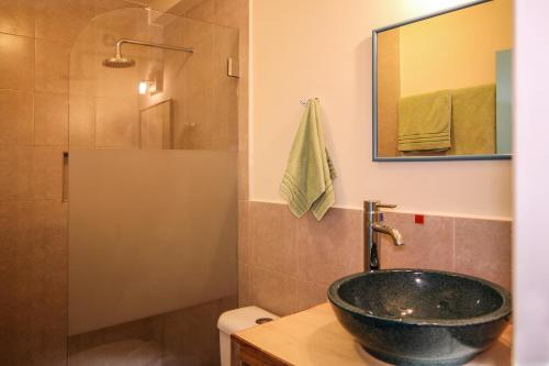 a bathroom with a sink and a shower at Inti Sisa Art Guesthouse in Guamote