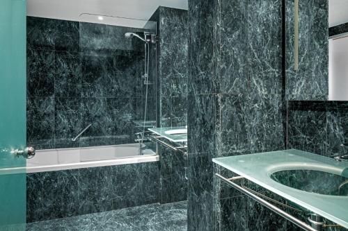 a bathroom with a shower and a sink and a tub at AC Hotel La Rioja by Marriott in Logroño