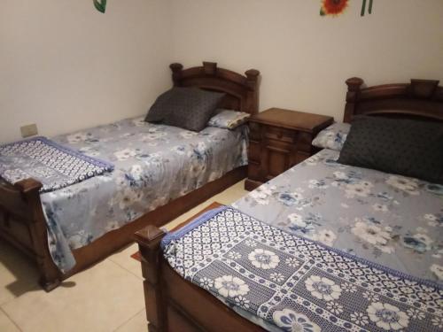 a bedroom with two beds with blue and white covers at Chalet On the Beach in Alexandria