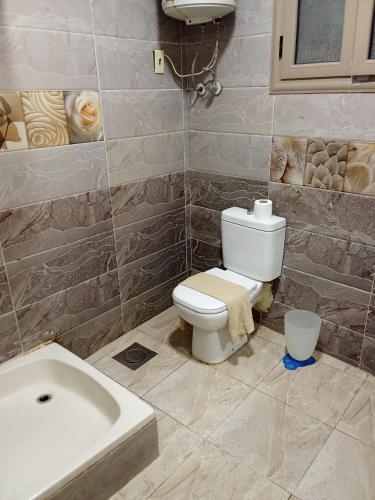 a bathroom with a toilet and a sink and a tub at Chalet On the Beach in Alexandria