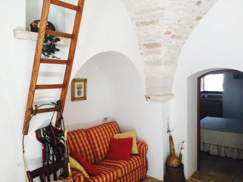 - un salon avec un canapé et une échelle dans l'établissement Trullo Vacanza, à Alberobello