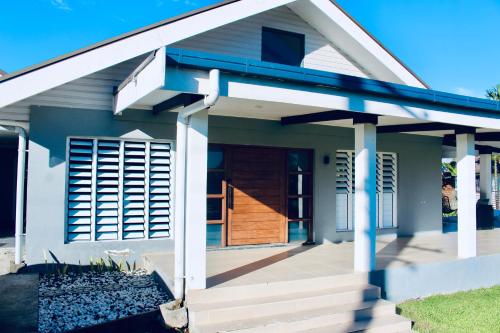 een klein huisje met blauwe verf en een veranda bij Villa Ahava in Pacific Harbour