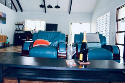 a table with a bottle of wine and a glass at Villa Ahava in Pacific Harbour