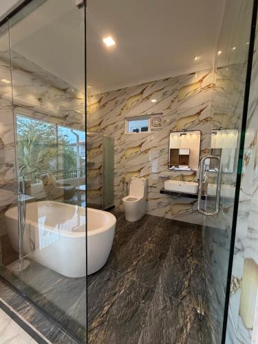 a bathroom with two sinks and a tub and two mirrors at White Land City Hotel in Dambulla