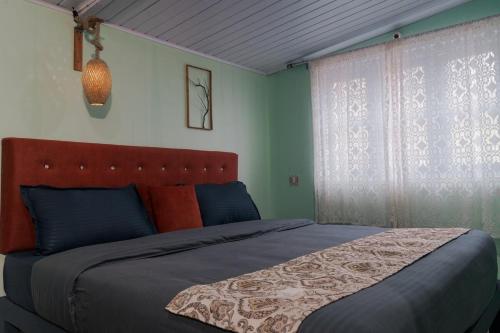 a bedroom with a large bed and a window at WildWood Stay in Madikeri