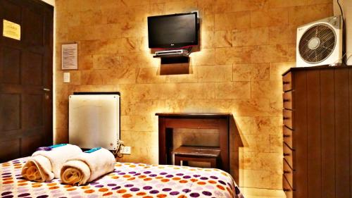 هوستيريا لوس ترونكوس في سانتا كلارا ديل مار: غرفة نوم مع تلفزيون وسرير مع مناشف