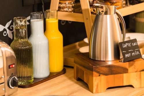 a counter with bottles of orange juice and a juicer at Mercure Bucharest Cantemir in Bucharest