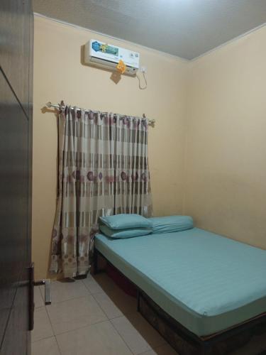 a small room with a bed and a heater at Arsya kost homestay in Balikpapan
