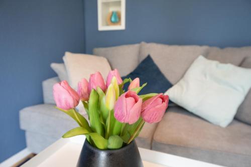 a vase filled with pink flowers on a table at Haus an der Düne Wohnung 9 in Lobbe