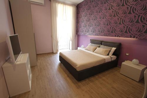 ナポリにあるAtelier 237の紫の壁のベッドルーム1室(ベッド1台付)