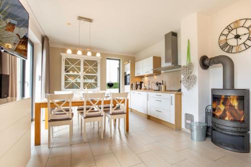 eine Küche und ein Esszimmer mit einem Tisch und einem Kamin in der Unterkunft Strandhaus Bernsteinsammler in Ostseebad Sellin