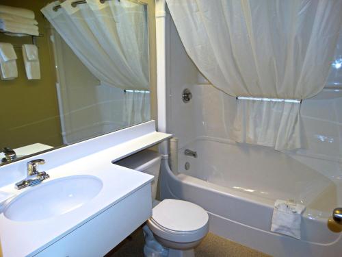 a bathroom with a sink and a toilet and a tub at Amsterdam Inn & Suites Moncton in Moncton