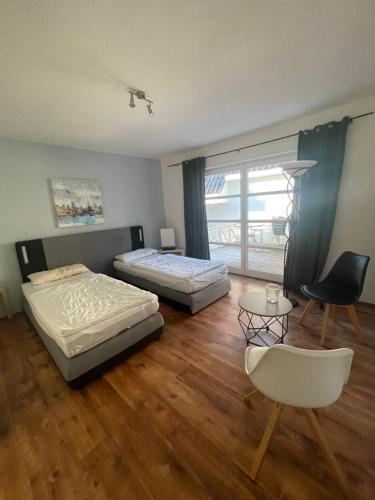 a bedroom with two beds and a table and a chair at Hamburger Villenviertel, ganzes Haus mit 5 Einbettzimmern,1 Esszimmer in Hamburg