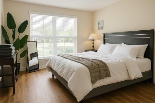 a bedroom with a large bed and a window at Dreamy 2BR Home with BQQ I Gym & Pool in Houston