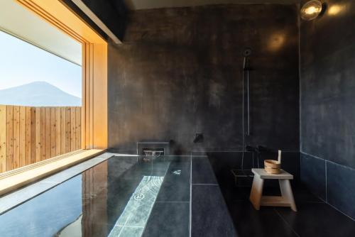a black bathroom with a tub and a window at ICHI -en- in Fujikawaguchiko