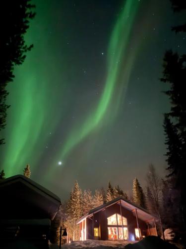 a cabin with the aurora in the sky at Villa Raanujärvi in Romakkaniemi