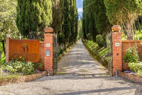 un vialetto che conduce a un giardino con alberi e un cartello di Casa Febea a Chiusi