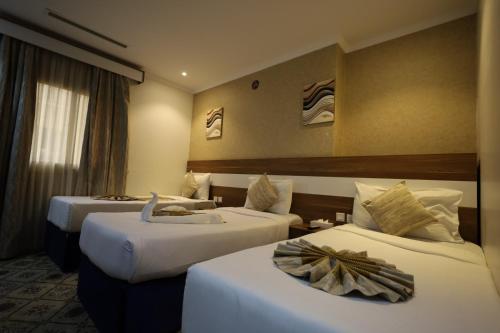 a hotel room with two beds and a room with two at Maysan AL Multaqa Hotel in Al Masfalah
