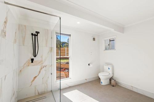 a bathroom with a shower and a toilet at Mountain Escape Cozy 3-Bedroom Retreat with Outdoor Entertaining in North Tamborine