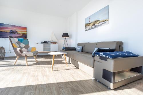 ein Wohnzimmer mit einer Couch und einem Sessel in der Unterkunft Penthouse Heimathafen in Lauterbach in Lauterbach