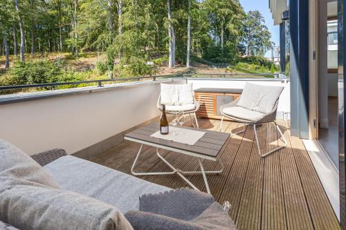 een balkon met een bank, 2 stoelen en een tafel bij Villa Baltic Pearl Penthouse in Ostseebad Sellin