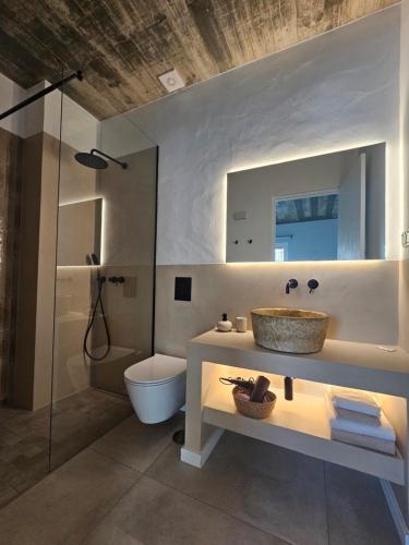 a bathroom with a sink and a toilet and a mirror at Sunset Guesthouse - Costa Vicentina in Aljezur
