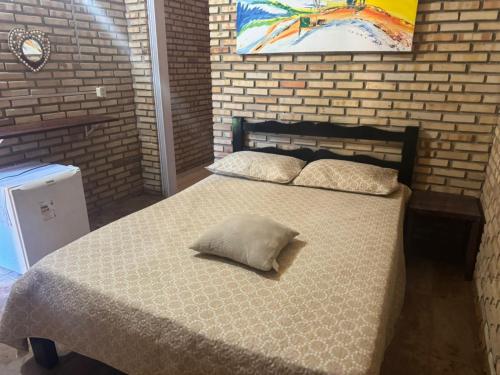 a bedroom with a bed with a pillow on it at Casa De Praia 9 quartos Em Aguas Belas, CE in Cascavel