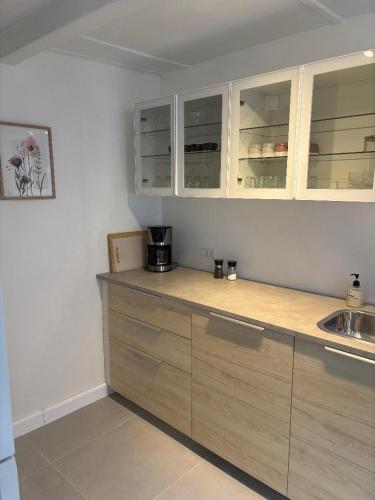 een keuken met houten kasten en een aanrechtblad bij Charmerende byhus midt i Assens in Assens