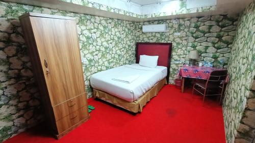 una camera da letto con un letto e un tavolo in una stanza di Hotel Golden Bird a Dhaka