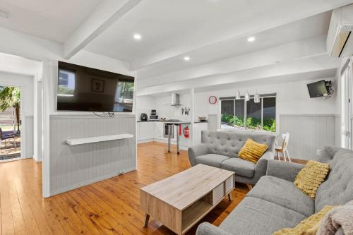 a living room with a couch and a table at Mountain Escape Cozy 3-Bedroom Retreat with Outdoor Entertaining in North Tamborine