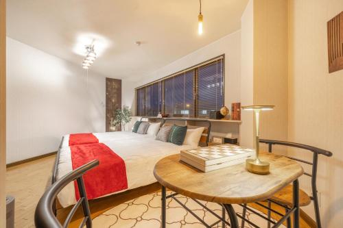 a bedroom with a bed and a table with a table sidx sidx sidx at Cozy Stay Kamui in Asahikawa