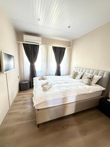 a bedroom with a large white bed in front of a window at Guesthouse Zornitsa in Hisarya