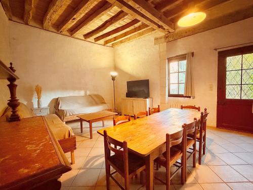 a living room with a wooden table and a bed at Aux Ecuries du Signe in Amboise