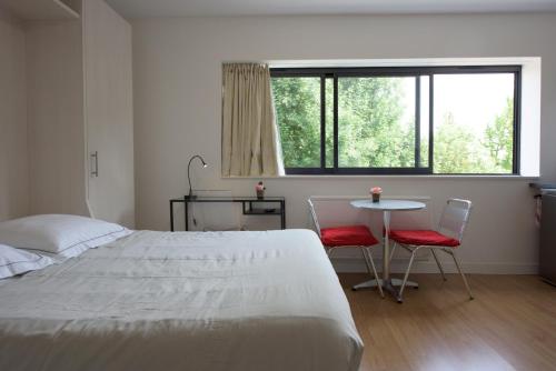 マルク・アン・バルールにあるAppartement Lille Metropolysのベッドルーム1室(ベッド1台、テーブル、椅子2脚付)