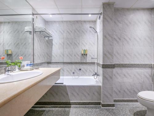 a bathroom with a shower and a tub and a sink at Pavillon Winter Luxor in Luxor