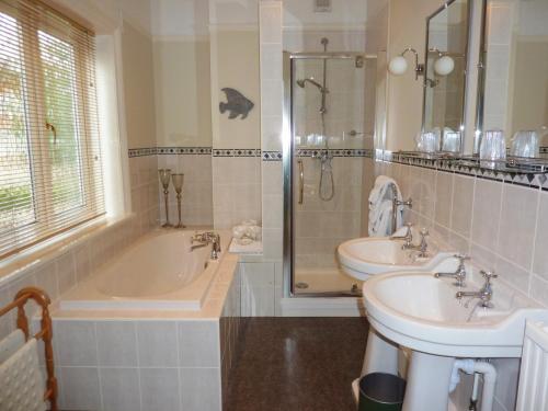 a bathroom with two sinks and a tub and a shower at The Manse B&B in Eastbourne