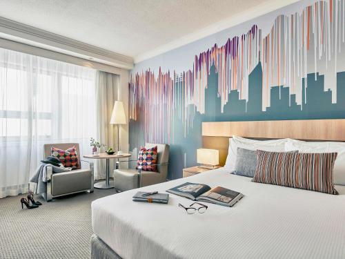 een hotelkamer met een bed en een stadsmuurschildering bij Mercure Perth in Perth