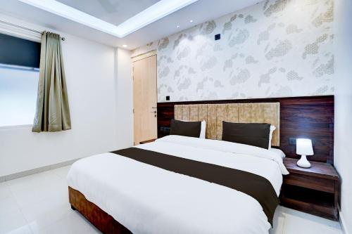 een slaapkamer met een groot wit bed en een raam bij Townhouse Oak Ram Lala Mandir Kanpur Formerly Hotel Sun Rise in Kaliānpur