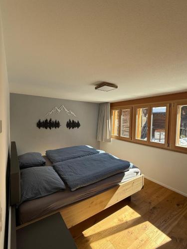 a bedroom with a bed with blue pillows on it at Larix in Ulrichen