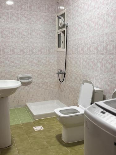 ein Badezimmer mit Toilette und Waschbecken in der Unterkunft أجاويد لشقق المفروشة 1 Ajaweed Residence in Salalah