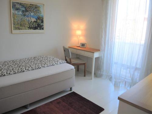 a bedroom with a bed and a desk with a lamp at Residenza Golf Parco by Fewotessin in Ascona