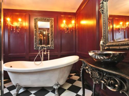a bathroom with a tub and a mirror at Buddha Villa in Arillas