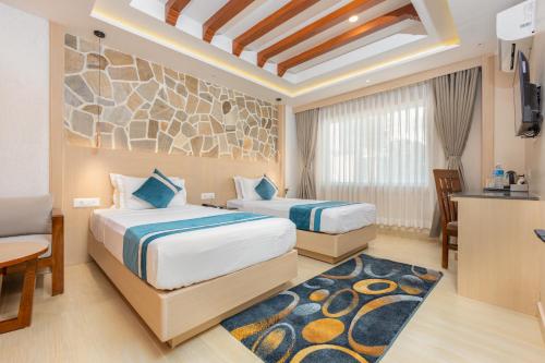 a hotel room with two beds and a kitchen at Tulsi Kathmandu Hotel in Kathmandu