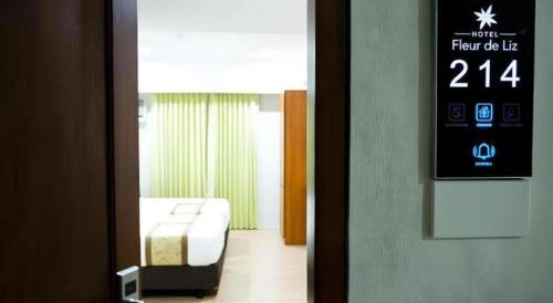 ein Zimmer mit einem Bett und einer Uhr an der Tür in der Unterkunft Hotel Fleur de Liz in Tagbilaran